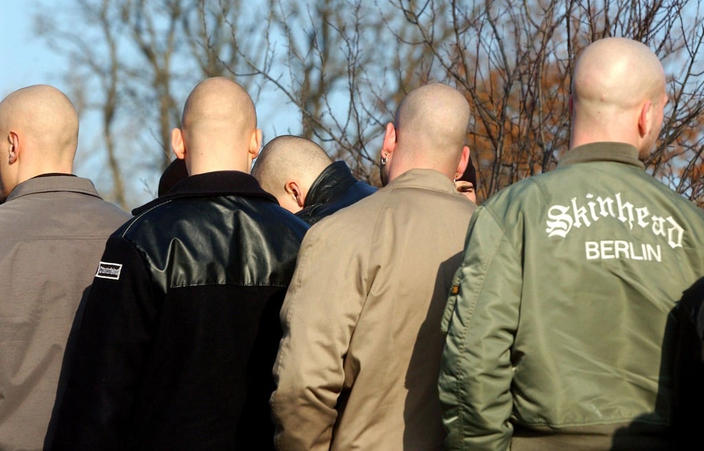 Junge Neonazis stehen während einer Demonstration zusammen.