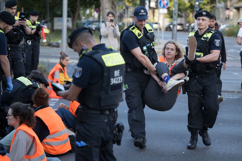 Ein Aktivist der Klimaschutzgruppe Letzte Generation wird während einer Straßenblockade auf dem Mehringdamm von Polizeibeamten weggetragen.
