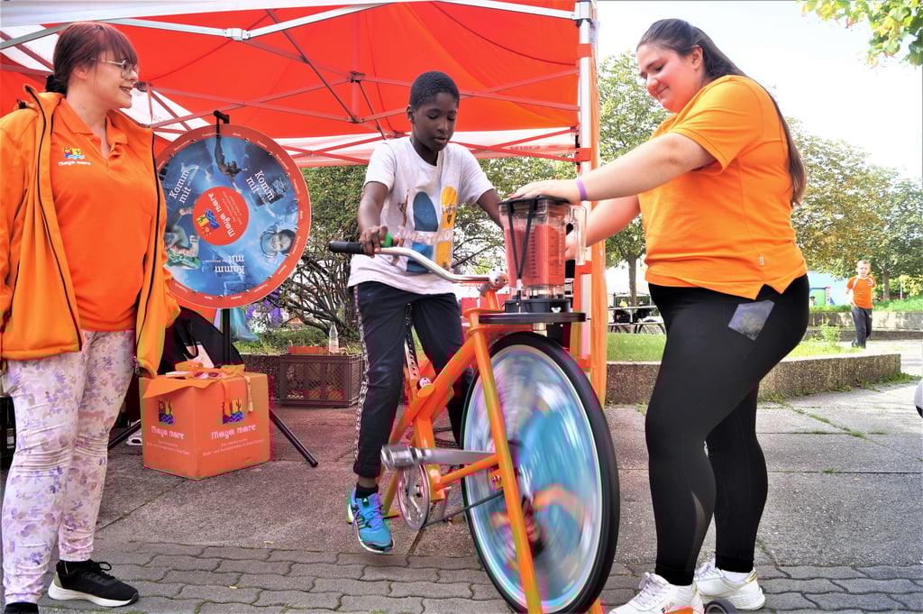 Abramane Faro (8) strampelt auf dem Smoothie-Bike, Nadine Seifert (li.) und Jasmin Apel vom Maya Mare assistieren.
