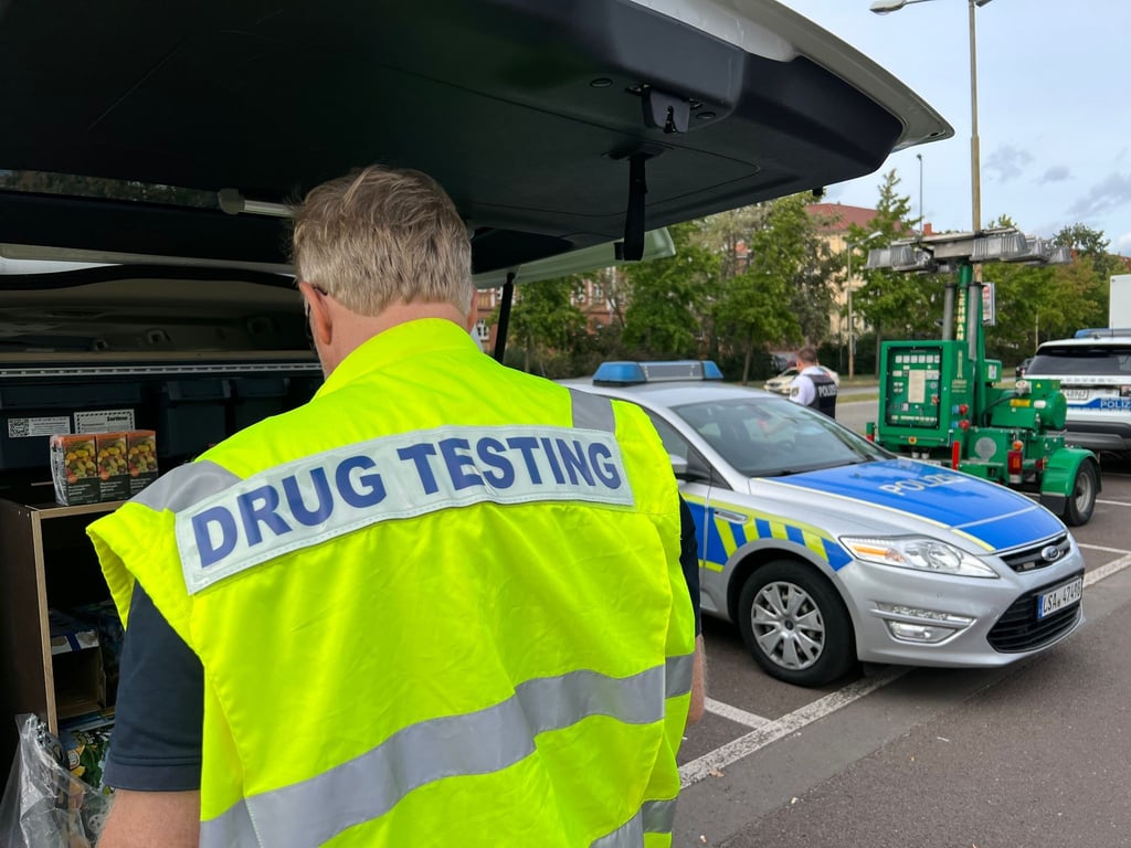 Ein Polizist untersucht eine Probe auf Rückstände von Drogen.