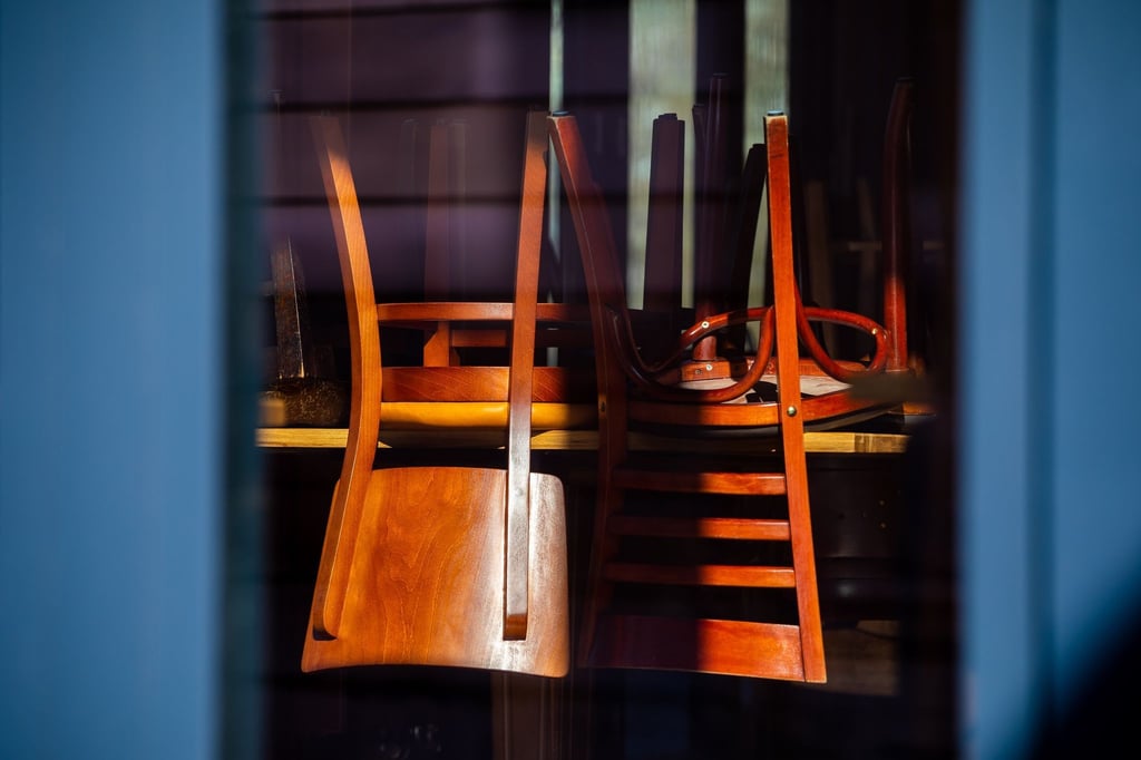 Hochgestellte Stühle sind im einfallenden Sonnenlicht in einem Restaurant in der Altstadt zu sehen.