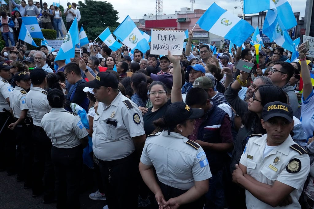 Während einer Demonstration in der Hauptstadt hält eine Frau ein Schild mit der Aufschrift „Parasiten raus“ in die Höhe. Tausende Menschen protestieren in Guatemala gegen die Generalstaatsanwaltschaft.