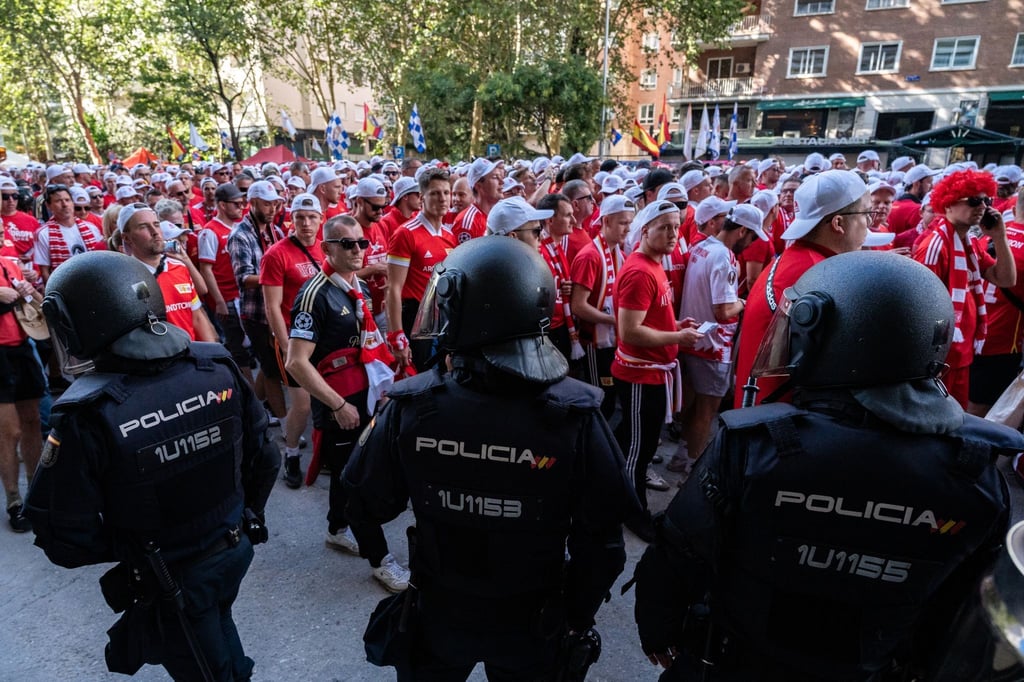 Zahlreiche Fans des 1. FC Union Berlin gehen an Polizisten auf dem Paseo de la Castellana vorbei.