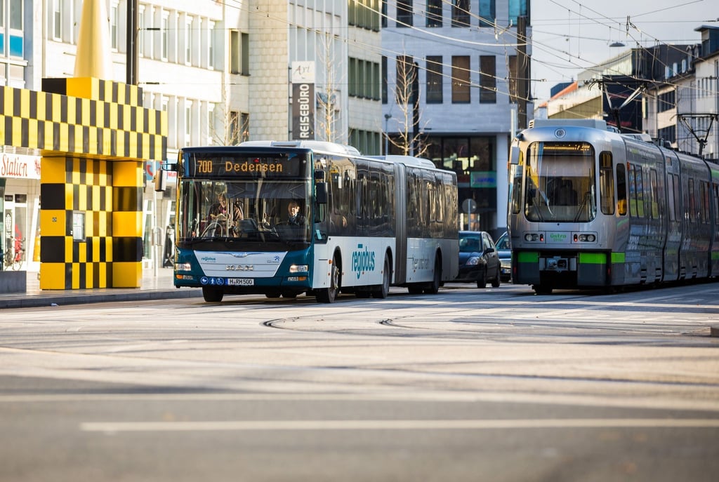 Ein Linienbus der Regiobus Hannover GmbH und eine Straßenbahn der Üstra Hannoversche Verkehrsbetriebe.