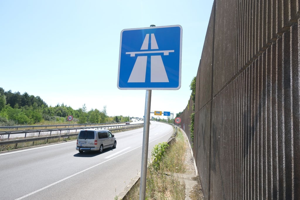 Ein Schild mit dem Symbol „Autobahn“ ist am Straßenrand zu sehen.