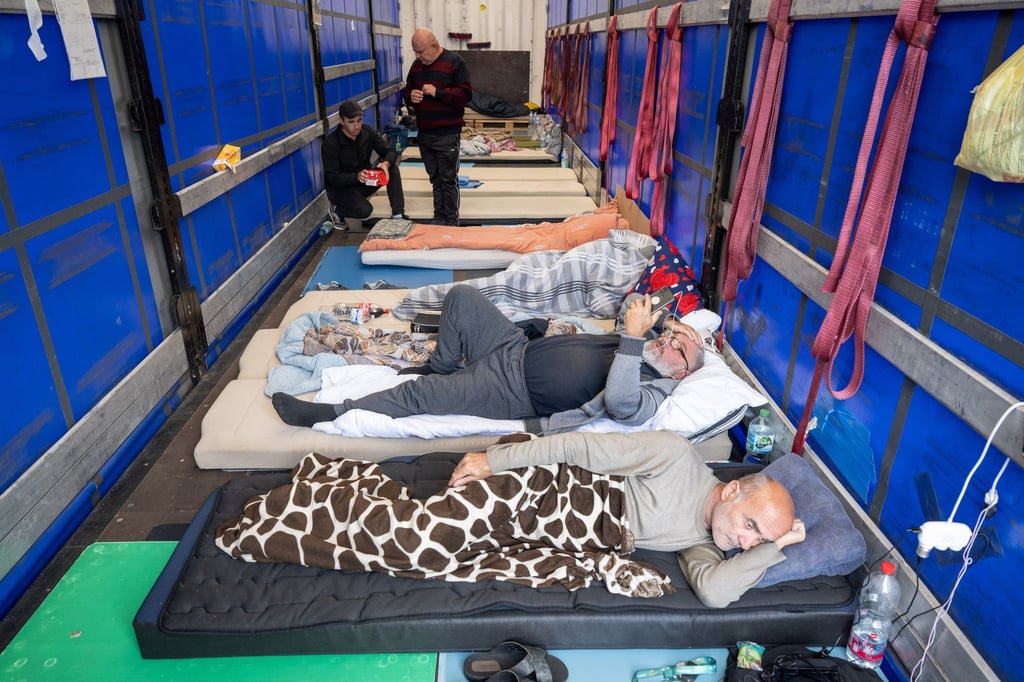 Trucker aus Georgien liegen auf einem Matratzenlager auf der Ladefläche eines Lkw. Sie sind in einen Hungerstreik getreten.