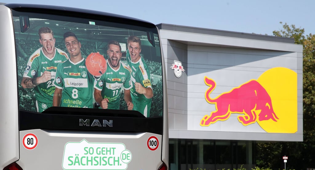 Der Bus der Handballer am Cottaweg neben dem Logo von Red Bull.