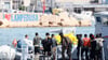 Gerettete Migranten stehen auf einem Boot der italienischen Finanzpolizei, bevor sie im Hafen der sizilianischen Insel Lampedusa von Bord gehen.