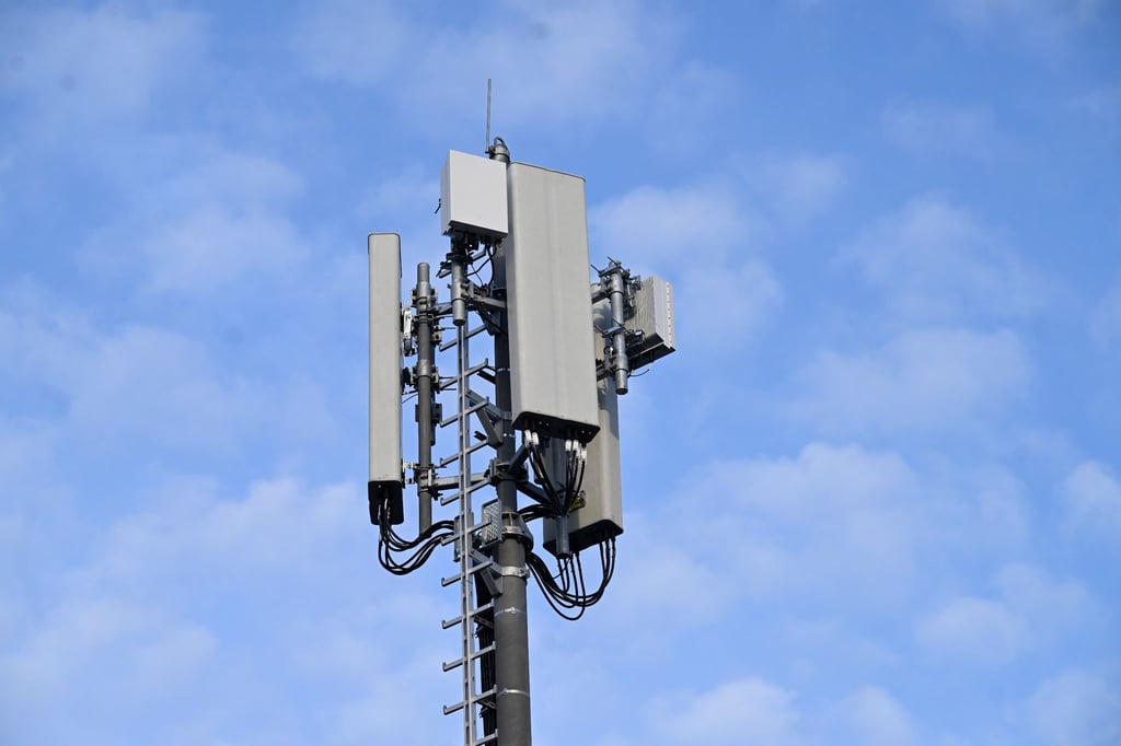 Ein 5G-Mobilfunkmast steht auf einem Hochhaus.