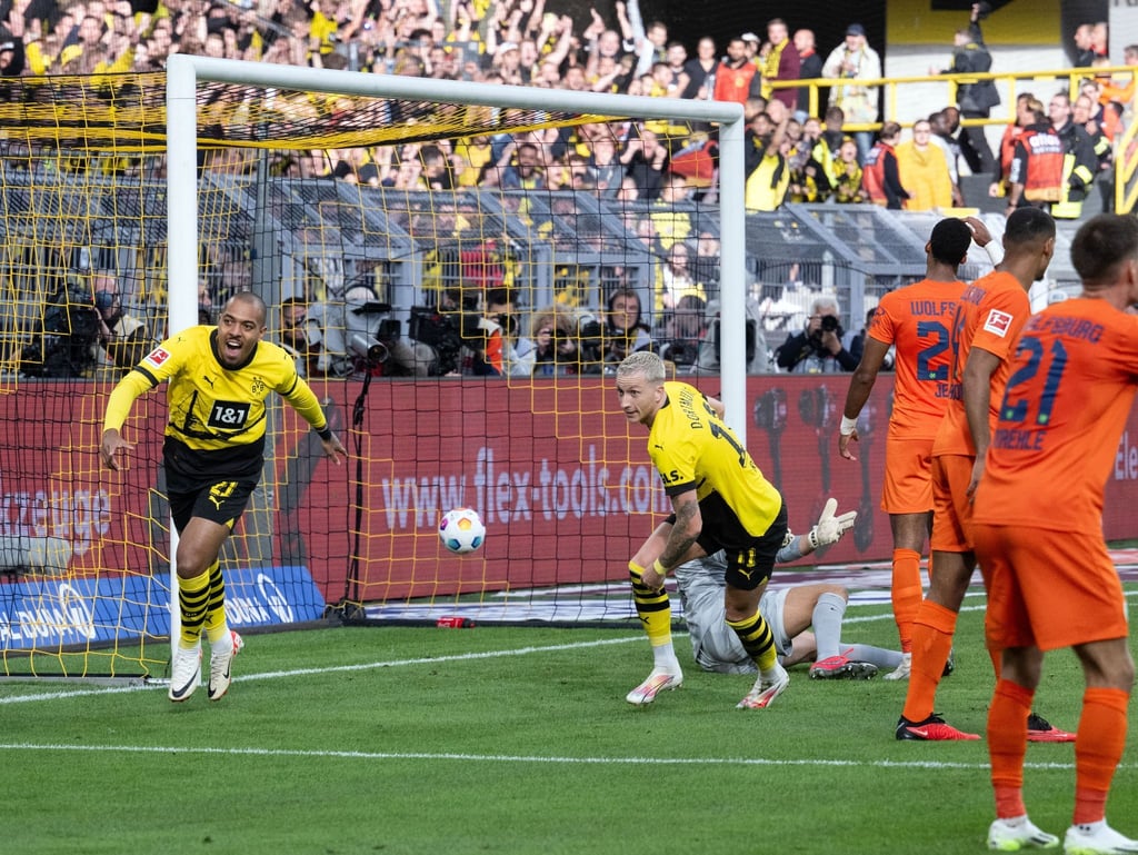 Dortmunds Marco Reus (M) jubelt mit Donyell Malen (l) über seinen Treffer zum 1:0.