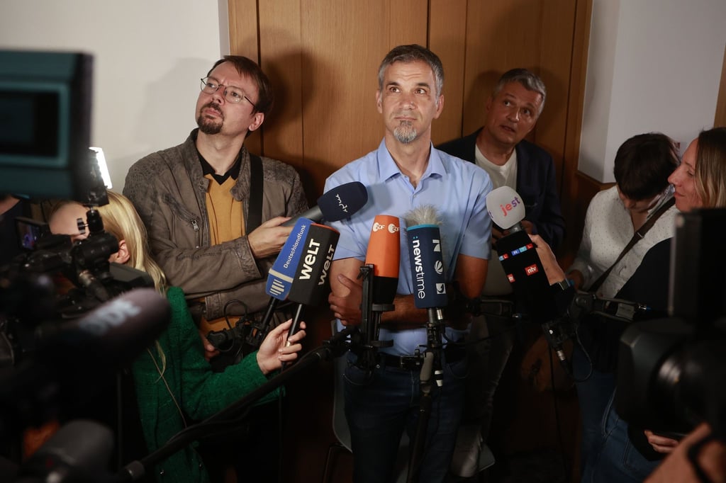 Wahlsieger Kai Buchmann (M) steht nach der Stimmenauszählung vor Journalisten.