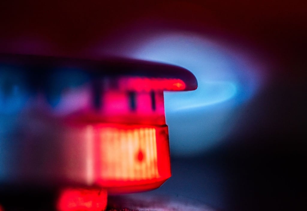 Die Flamme eines Gasherdes brennt in einer Küche.