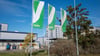 Vor einem Teil der Verbio Vereinigte BioEnergie AG-Anlage wehen Flaggen mit dem Logo des Unternehmens.