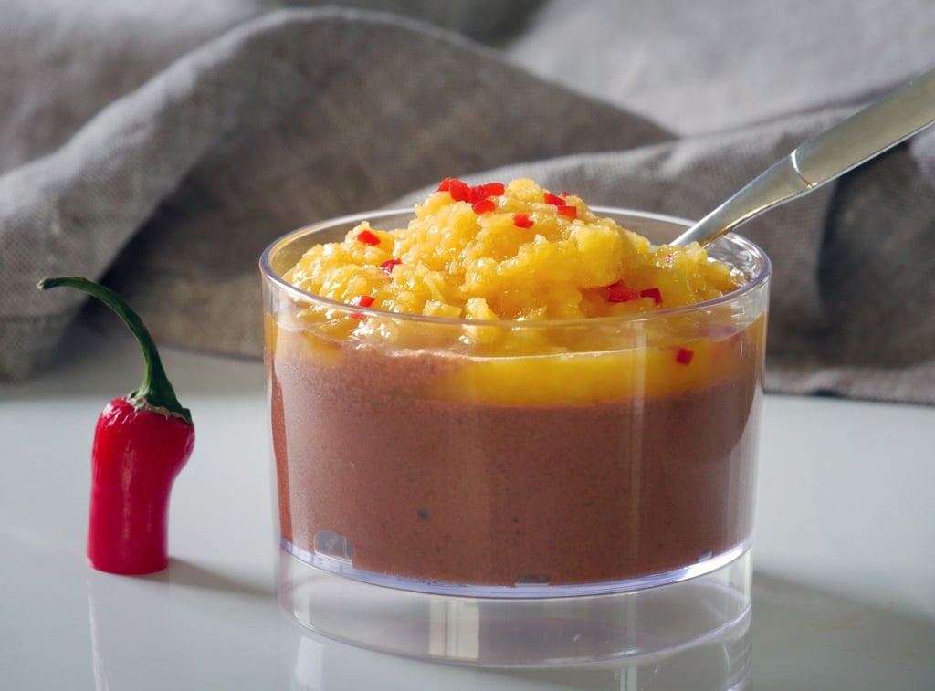 Für die vegane Mousse au Chocolat mit Mango & Chili wird geschmolzene Schokolade vorsichtig unter den Eischnee gehoben und kalt gestellt. Ein Püree aus frischer Mango, Saft und etwas Chili toppt den Schoko-Schnee.