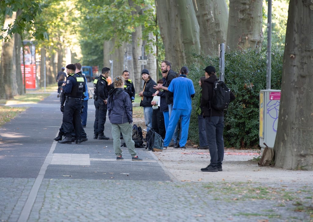Aktivisten und Unterstützer der Umweltschutz-Gruppe Letzte Generation stehen nach einer Blockade an der Treskowallee.