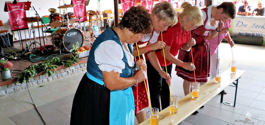 Mittels Strohhalm sind in Premsendorf die Gläser zu leeren und das unter den Anfeuerungsrufen des Publikums.