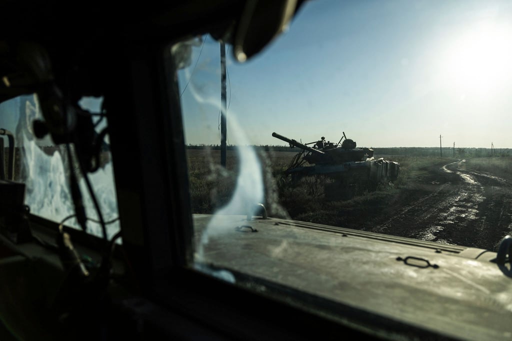 Ein zerstörter Panzer ist durch das Fenster eines Fahrzeugs an der Frontlinie in der Nähe von Klischtschijiwka bei Bachmut zu sehen.