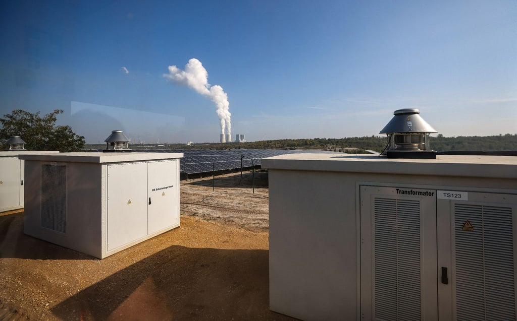 Die Transformatoren der neuen Photovoltaik-Anlage vor der Kulisse des Braunkohlekraftwerks Lippendorf.
