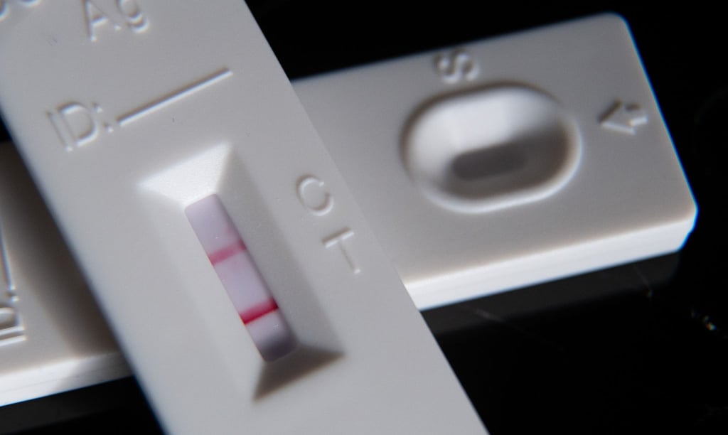 Ein positiver Corona-Schnelltest liegt auf einem weiteren Schnelltest.