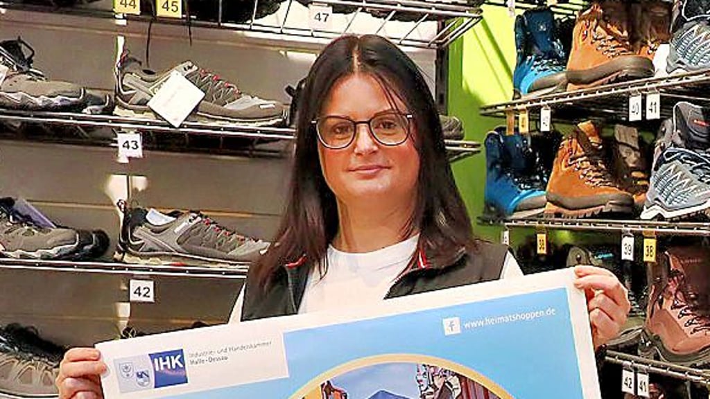 Claudia Lucks von Sport Liebig präsentiert das Plakat fürs Heimat-shoppen.