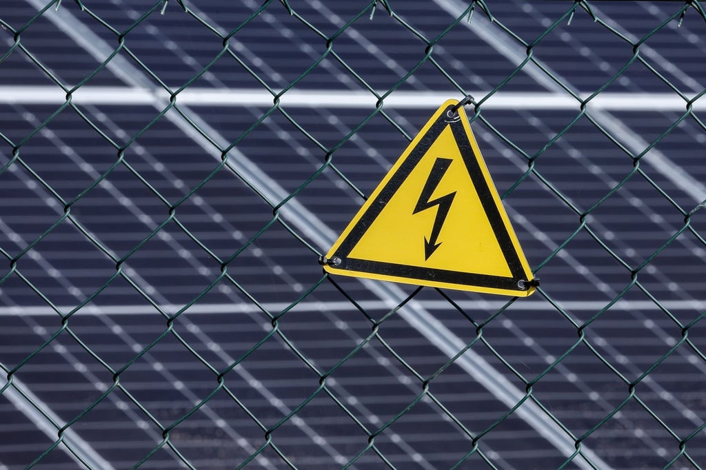 Ein Warnschild warnt vor Starkstrom an der neuen Photovoltaik-Anlage.