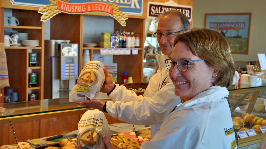 Tourismusstaatssekretärin Stefanie Pötzsch und Geschäftsführer der IMG, Robert Franke, präsentieren die Brötchentüten mit neuem Design in einer „Ihr Landbäcker“-Filiale in Stendal.