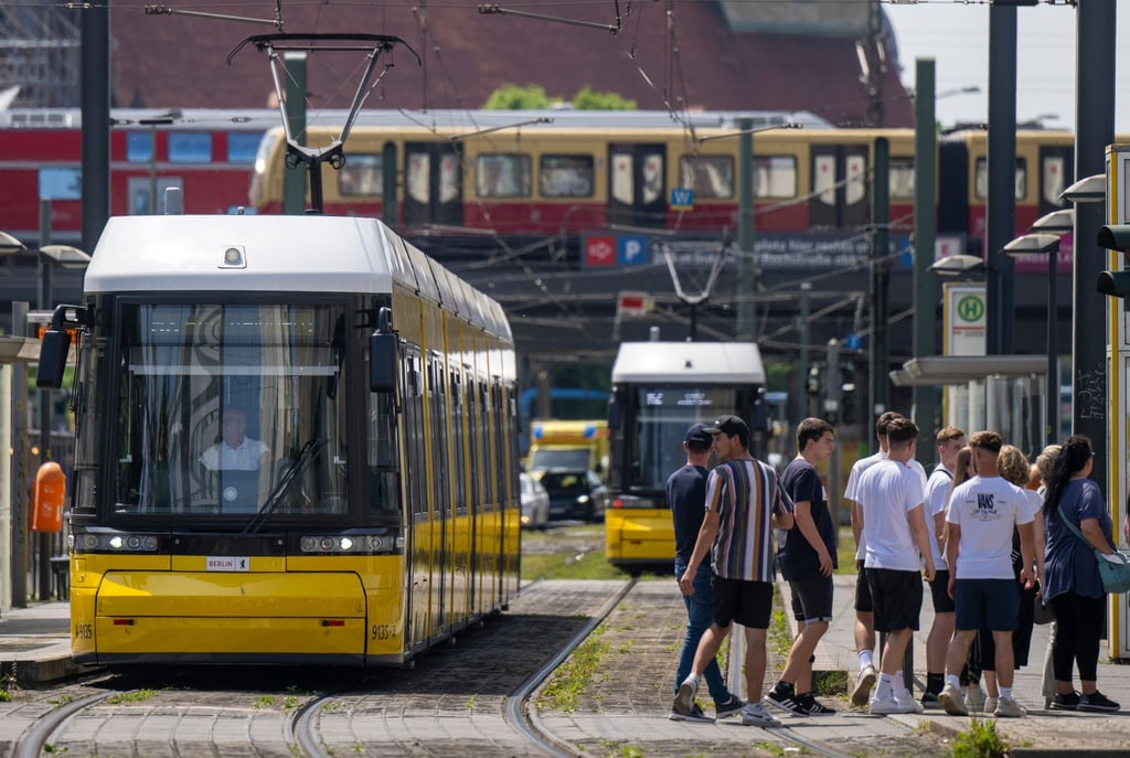 Eine Straßenbahn der BVG steht an einer Haltestelle am Alexanderplatz.