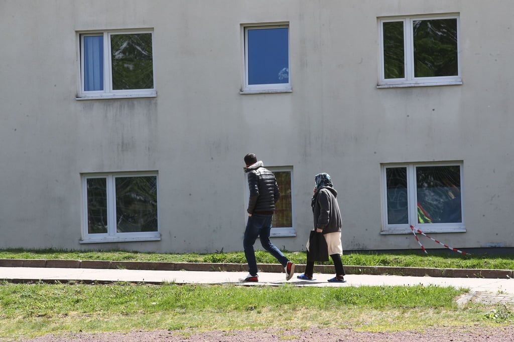 Asylbewerber gehen auf dem Gelände der Erstaufnahmeeinrichtung des Landes Thüringen spazieren.