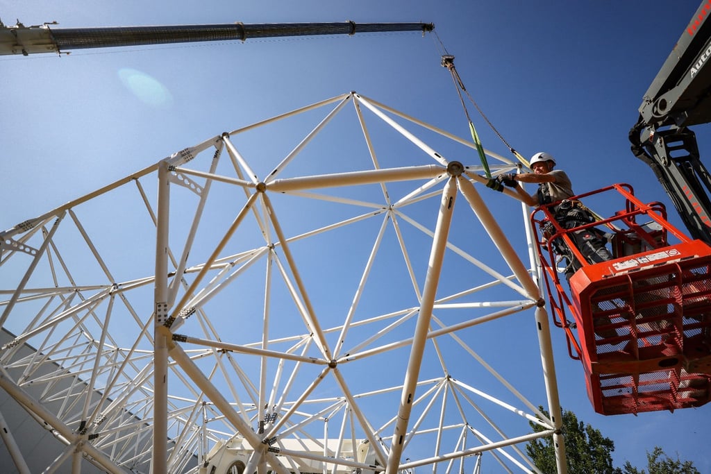Heiko Köppe (vorn) und Fabrice Sander montieren den Prototypen einer 18 Meter großen Parabolantenne.