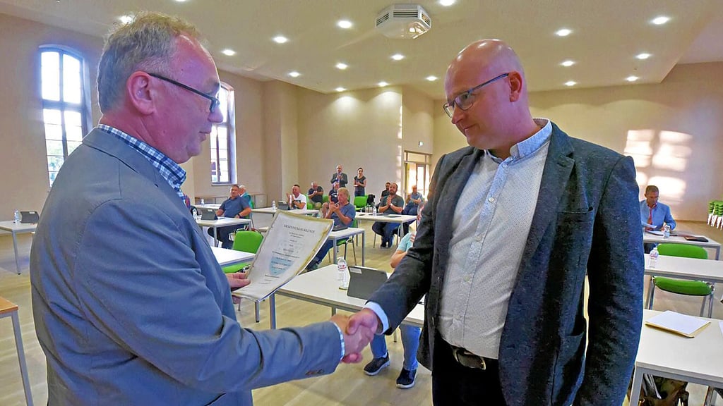 Der Stadtratsvorsitzende Mario Kempe überreicht Robert Käsebier die Ernennungskurkunde.