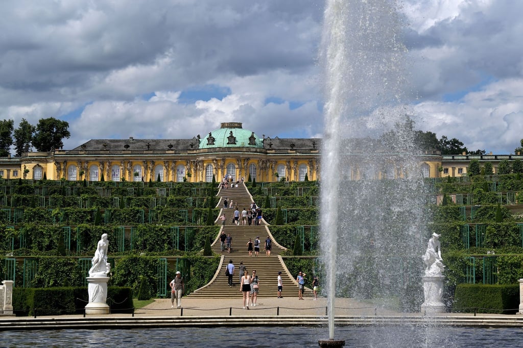 Eine Fontäne sprüht Wasser in die Luft im Park vor Schloss Sanssouci.