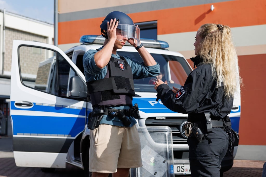 Polizei-Bewerber David Sauerwald probiert eine Einsatzausrüstung (Weste, Koppel, Helm, Schild) an.
