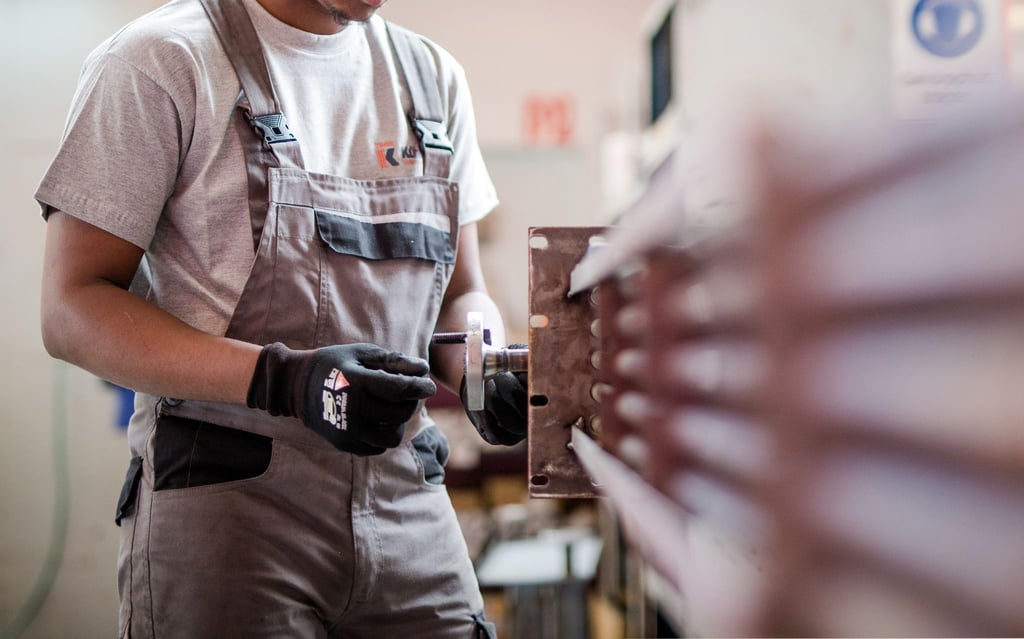 Ein Flüchtling aus Somalia arbeitet während eines Praktikums bei einem Industrieunternehmen in der Produktion. Es gibt Forderungen, die Arbeitsaufnahme für Flüchtlinge zu erleichtern.