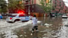 Ein Mann versucht im Stadtbezirk Brooklyn, einen Abfluss im Hochwasser zu reinigen. Inzwischen ist das Wasser wieder versickert.