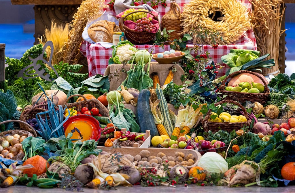 Ernteprodukte liegen bei einem Erntedankfest vor dem Altar.