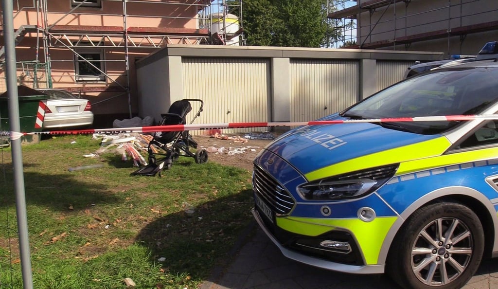 Ein Auto (links hinten) steht an einem Haus, nachdem der Fahrer zuvor eine Frau und ein Kind angefahren und lebensgefährlich verletzt hatte.
