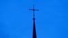 Kreuz einer evangelisch-lutherischen Kirche in der Abenddämmerung.