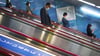 Menschen fahren auf einer Rolltreppe in eine U-Bahn-Station in Tokio.