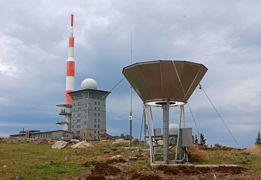 Dunkle Wolken ziehen über den Brocken und die Messinstrumente der Wetterwarte.