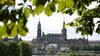 Die Blätter einer Kastanie rahmen die Kulisse der Altstadt mit der Katholischen Hofkirche (l) und dem Hausmannsturm.