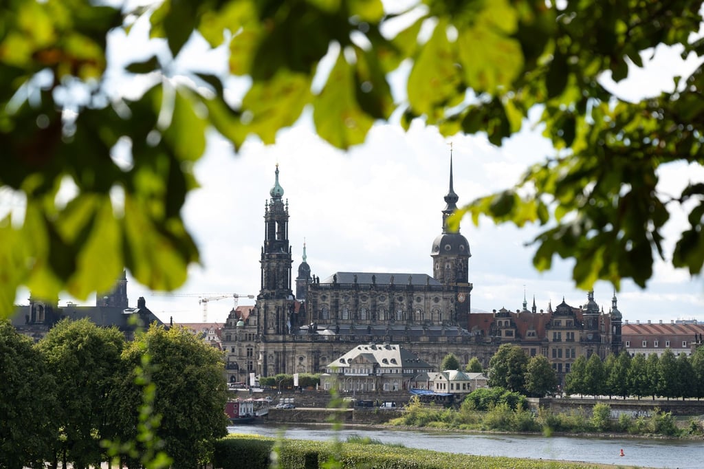 Die Blätter einer Kastanie rahmen die Kulisse der Altstadt mit der Katholischen Hofkirche (l) und dem Hausmannsturm.