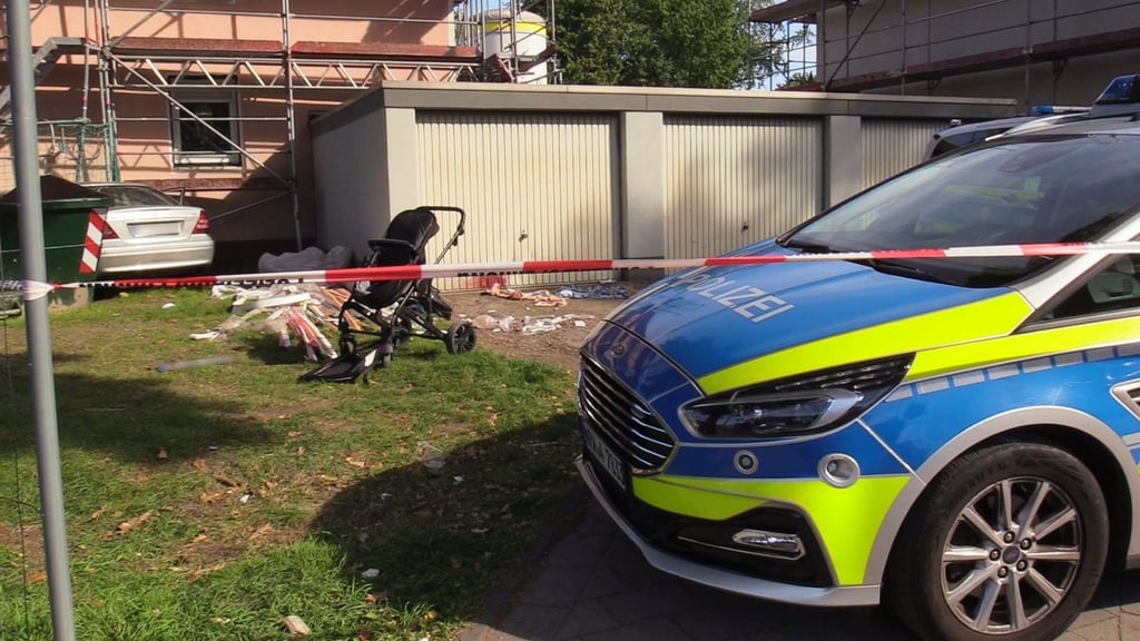 Ein Auto (links hinten) steht an einem Haus, nachdem der Fahrer zuvor eine Frau und ein Kind angefahren und lebensgefährlich verletzt hatte.
