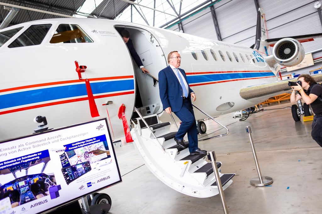 Boris Pistorius (SPD) verlässt bei seinem Besuch vom Deutschen Zentrums für Luft- und Raumfahrt (DLR) ein Forschungsflugzeug in einem Hangar.