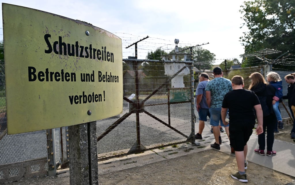 Besucher besichtigen am Tag der Deutschen Einheit die Reste von Mauer und Stacheldraht im Deutsch-Deutschen Museum Mödlareuth.