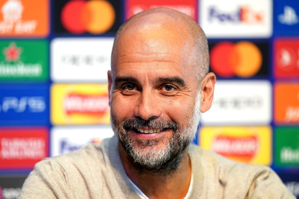 Pep Guardiola, Trainer von Manchester City, lächelt während einer Pressekonferenz.