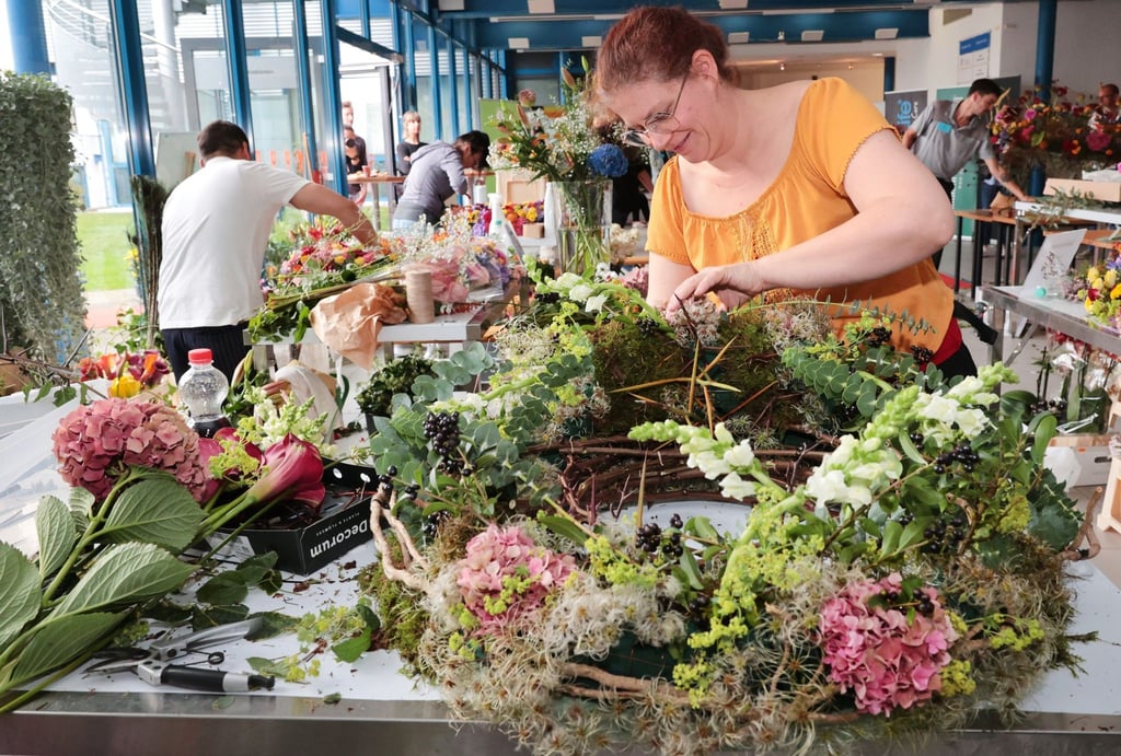 Diana Tröger (vorne) von "Rosenrot" aus Halle / Saale arbeitet an einem Gesteck.