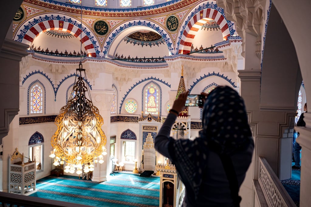 Eine Besucherin fotografiert die Sehetlik-Moschee am Columbiadamm in Berlin.