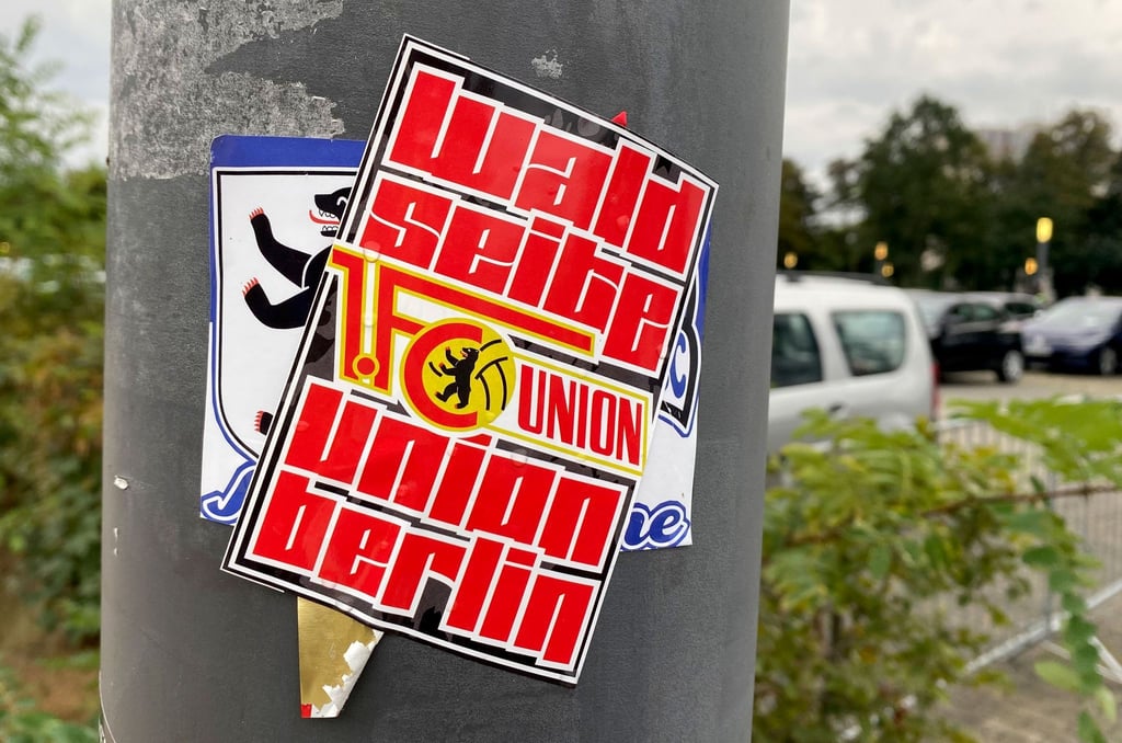 Ein Union-Fanaufkleber mit der Aufschrift „Waldseite Union Berlin“ klebt über einem Fanaufkleber von Hertha BSC.
