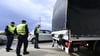 Polizisten kontrollieren einen Lastwagen und Autofahrer am Grenzübergang Berg in Österreich.
