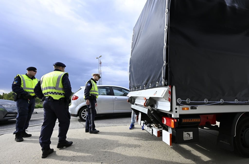 Polizisten kontrollieren einen Lastwagen und Autofahrer am Grenzübergang Berg in Österreich.